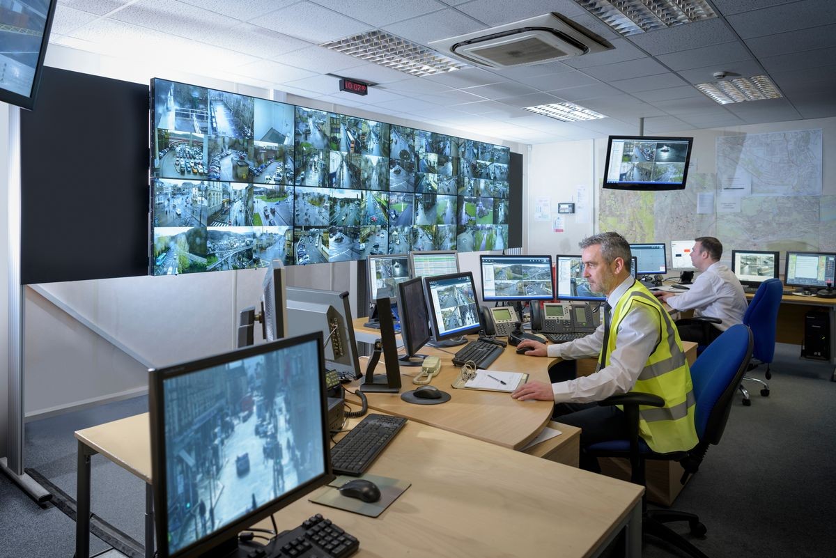 Security guards in security control room with video wall